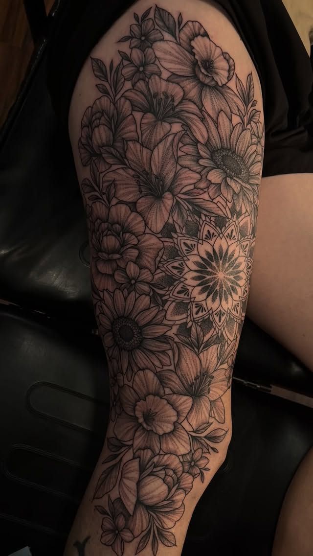 Black and grey flowers with a mandala in dotwork on a leg