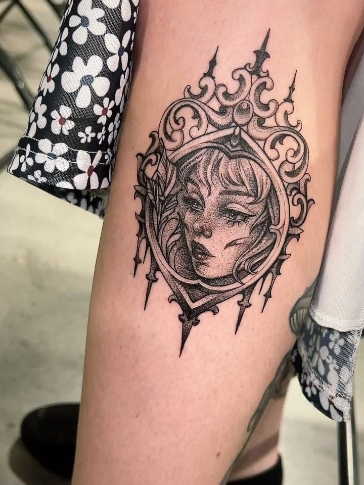 Black and grey girl inside an ornate frame on an arm
