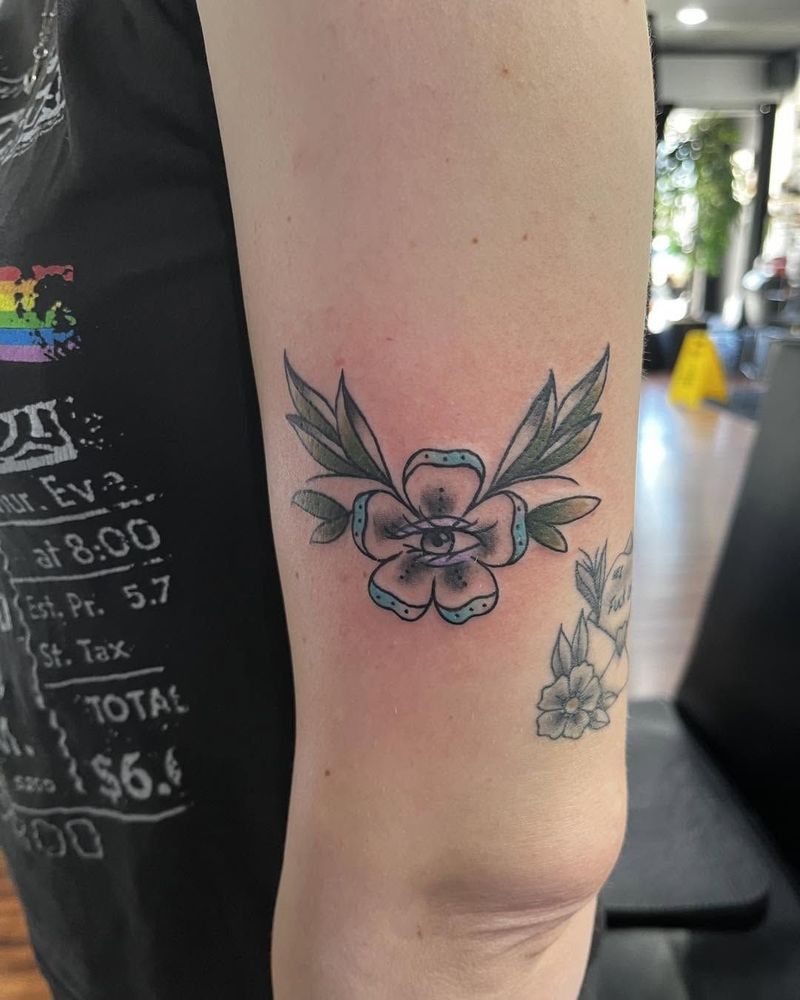 Flower with an eye in the center and leaves, on an upper arm