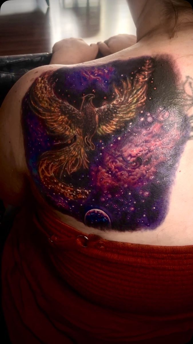 Color phoenix over a purple galaxy on a back